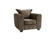 A plush tufted armchair in taupe-brown suede upholstery, styled in a modern living room with white marble floors, large windows, and neutral decor.